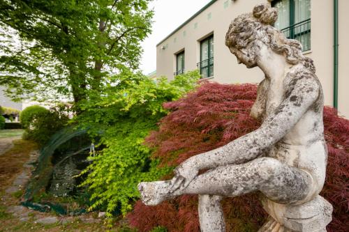 a statue of a girl sitting on a bench at Hotel all'Orso in Biancade