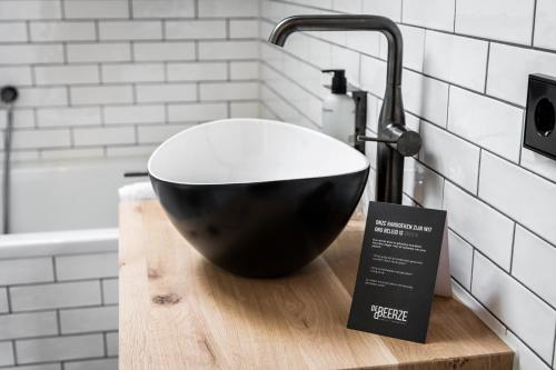 a black bowl sitting on a cutting board in a bathroom at Boutique Hotel De Beerze in Middelbeers