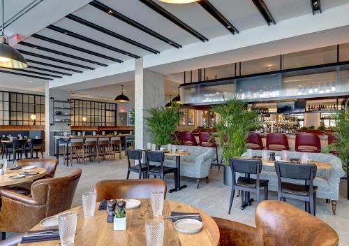 Un restaurante con mesas y sillas y un bar. en The Colonnade Hotel, en Boston