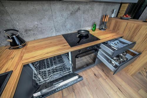 a kitchen with a wooden counter top and a dishwasher at Portowa Art in Nowa Sól