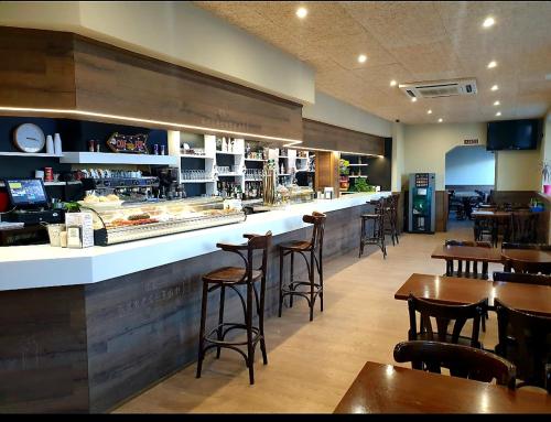 a restaurant with a bar with chairs and tables at Hotel El Peregrino in Est&eacute;par