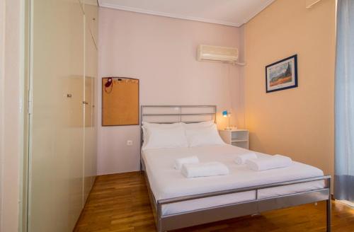 Un pequeño dormitorio con una cama blanca y una puerta de cristal en Laconian Collection Amalias, en Esparta