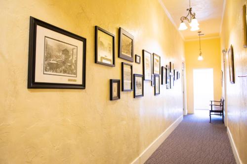 un couloir avec un bouquet de photos sur un mur dans l'établissement Letson Loft Hotel, à Bisbee