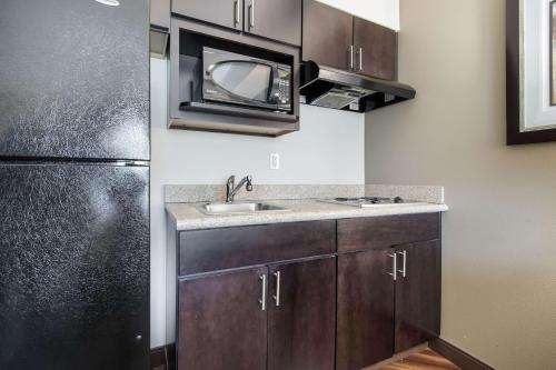 a kitchen with a sink and a microwave at La Quinta by Wyndham Auburn in Auburn