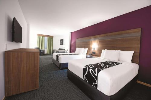 a hotel room with two beds and a television at La Quinta by Wyndham San Jose Chiapa Puebla in San José Chiapa