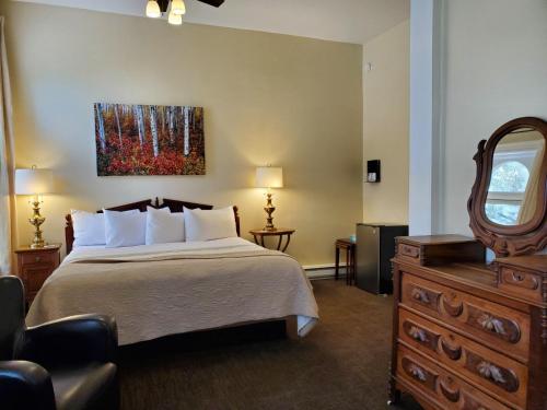 a hotel room with a bed and a mirror at Hotel Ouray - for 12 years old and over in Ouray