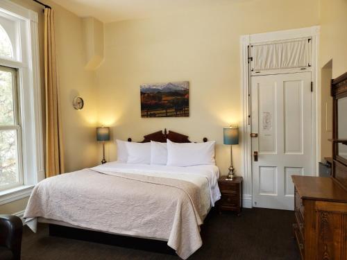 a bedroom with a large bed with white pillows at Hotel Ouray - for 12 years old and over in Ouray