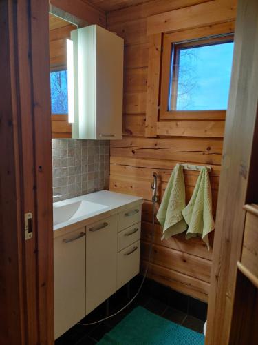 eine kleine Küche mit einem Waschbecken und einem Fenster in der Unterkunft Kaijonselän mökit Kaita in Kaitainen