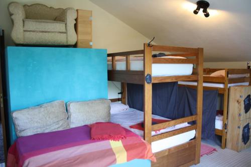 a bedroom with two bunk beds and a couch at Hostel on the Hill in Raposeira