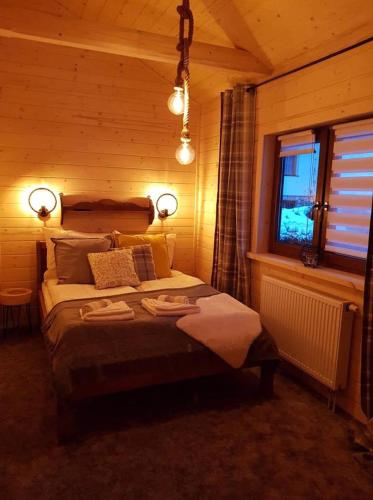 a bedroom with a bed with two towels on it at Śwarny Domek in Małe Ciche