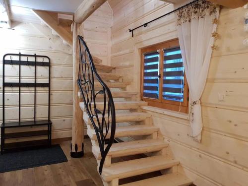 una escalera en una cabaña de madera con ventana en Śwarny Domek, en Małe Ciche