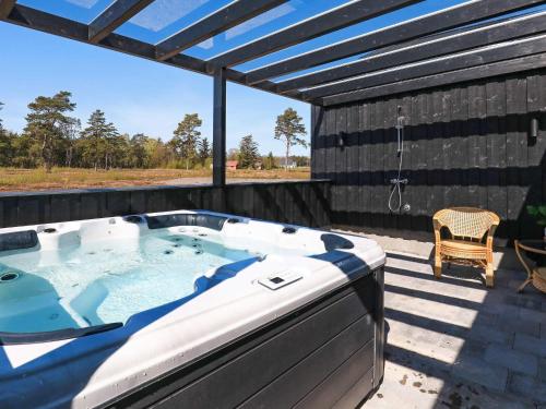 una bañera de hidromasaje en una terraza con patio en 14 person holiday home in L s, en Læsø
