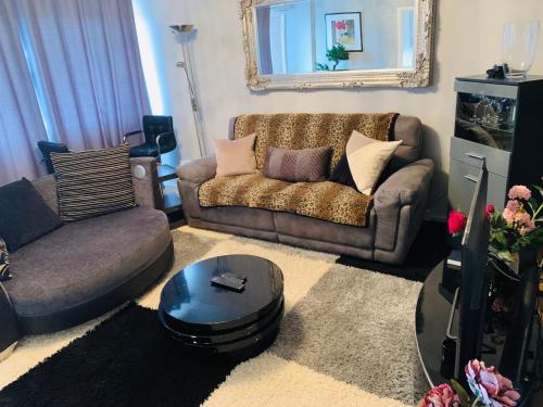 a living room with a couch and a table at CyCy Apartment in Aberdeen