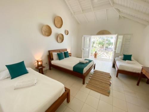 a large room with two beds and a window at El Mosquito Boutique Hotel Playa Bonita in Las Terrenas