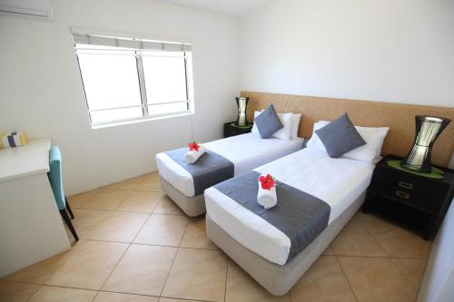 a hotel room with two beds and a window at Moana Sands Beachfront Villas in Rarotonga