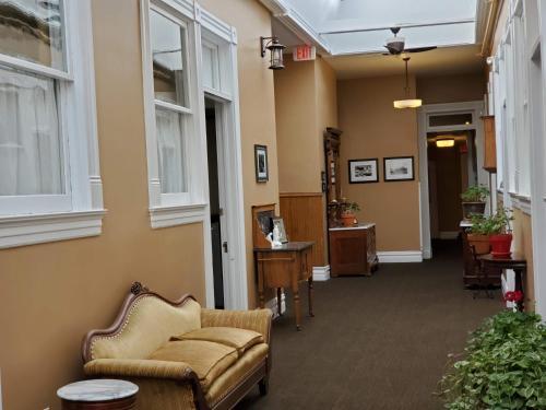 a hallway with a chair and a desk and windows at Hotel Ouray - for 12 years old and over in Ouray