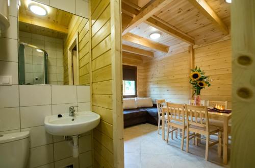 a bathroom with a sink and a table and chairs at Ross-domki in Sarbinowo