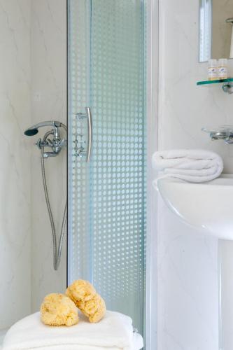 a bathroom with a shower with two donuts on a stool at Elounda Akti Olous (Adults Only) in Elounda