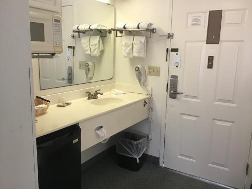 a bathroom with a sink and a mirror and a phone at Anastasia Inn - Saint Augustine in Saint Augustine