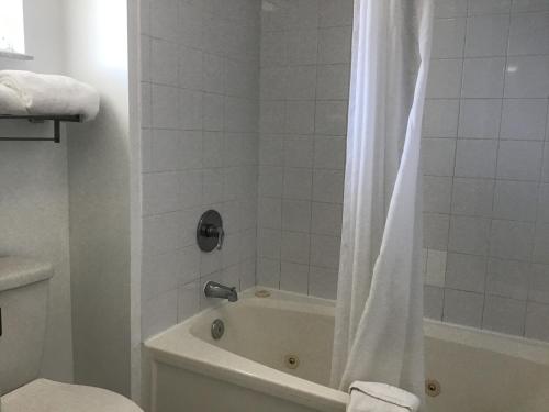 a bathroom with a tub and a shower with a shower curtain at Anastasia Inn - Saint Augustine in Saint Augustine