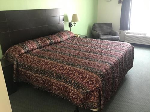 a hotel room with a bed and a chair at Anastasia Inn - Saint Augustine in Saint Augustine