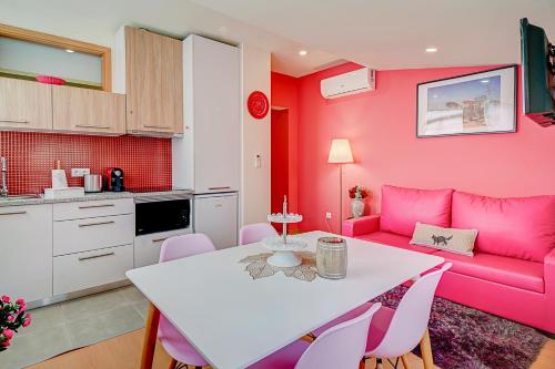 ein Wohnzimmer mit einem rosa Sofa und einem Tisch in der Unterkunft Port Wine Flats in Vila Nova de Gaia