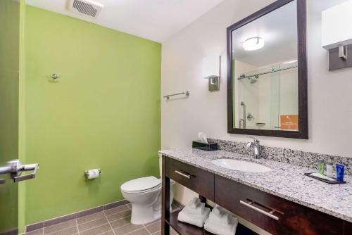 a bathroom with a sink and a toilet and a mirror at Sleep Inn Spokane Airport in Spokane