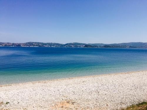 a beach with blue water and mountains in the background at Apartment Umag Nelly in Umag