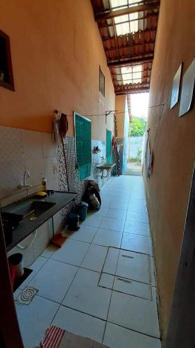 an empty kitchen with a sink and a tiled floor at Casa de praia, Camocim. in Camocim