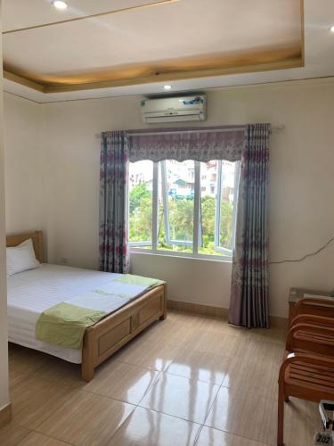 a bedroom with a bed and a window at Nhà Nghỉ Diễm Quỳnh in Noi Bai