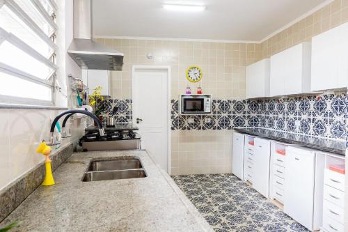 a kitchen with a sink and a microwave at Aluguel de Suítes por Temporada em Alto de Pinheiros in Sao Paulo