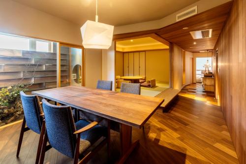 a dining room with a wooden table and chairs at Kifuno Sato in Mimasaka