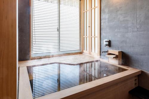 a bathroom with a window and a wooden bench at Kifuno Sato in Mimasaka