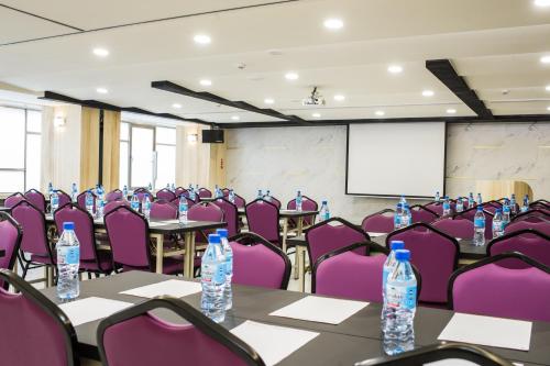a conference room with purple chairs and water bottles on tables at Red hotel in Yuanlin