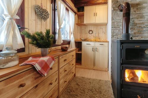 a kitchen with wooden cabinets and a stove at Chalet Tisa Velika Planina in Stahovica