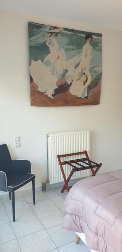a bedroom with a bed and a painting on the wall at Alexia's Apartments in Rio