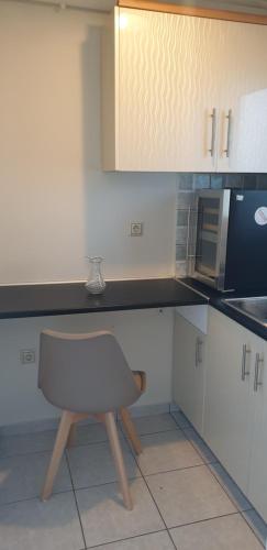 a chair in a kitchen with a counter top at Alexia's Apartments in Rio