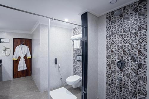 La salle de bains est pourvue de toilettes et d'une douche en verre. dans l'établissement Lemon Tree Hotel Gangtok, à Gangtok