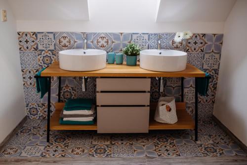 uma casa de banho com 2 lavatórios num balcão de madeira em Penzion U Kapličky em Znojmo
