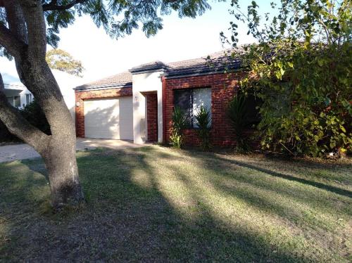 a brick house with a tree in the yard at Park View Holiday Getaway in Perth