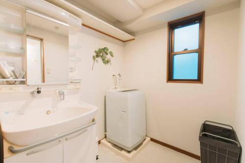 長崎市にあるgate nagasaki stay&greenの洗面台と鏡のある白いバスルーム