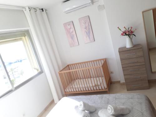a bedroom with a bed and a dresser and a window at urbanización puerto paraiso in Estepona
