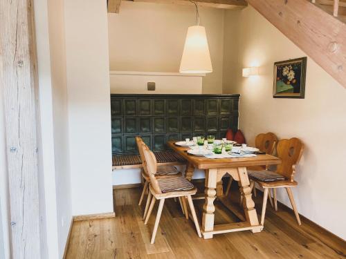 a dining room with a wooden table and chairs at Landhaus Sonneck in Weissensee