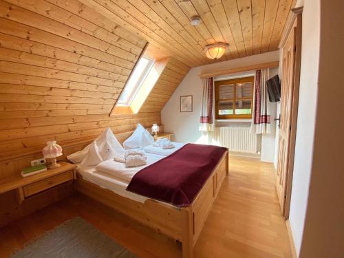 Schlafzimmer mit einem Bett mit Holzdecke in der Unterkunft Landhaus Sonneck in Weissensee
