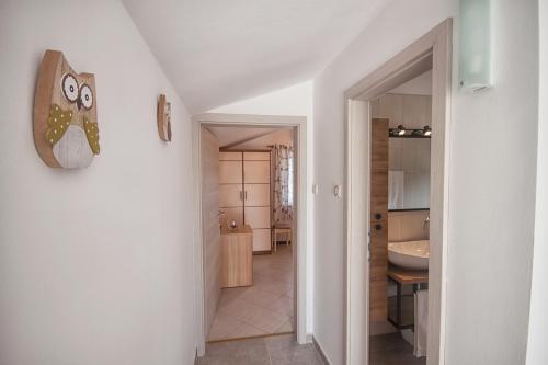 a hallway leading to a bathroom with a sink at Apartments Katarina Porat in Malinska