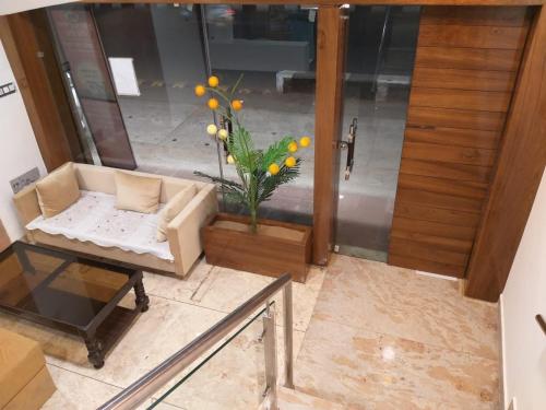 a living room with a couch and a vase of flowers at lords residency in Bhopal