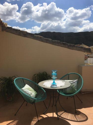 a table with two chairs and a glass vase on it at Cortijo Esquina B&B Guesthouse in Arboleas