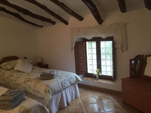 1 dormitorio con 2 camas y ventana en Cortijo Esquina B&B Guesthouse en Arboleas