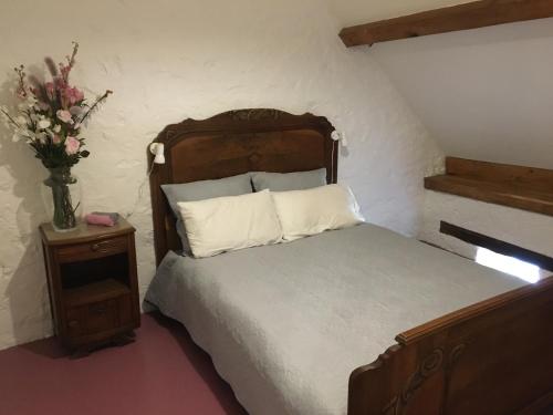 1 dormitorio con 1 cama y un jarrón de flores en Les Bouaux, Bardon, en Cussy-en-Morvan