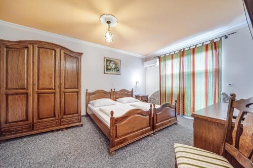 a bedroom with a wooden bed and a wooden cabinet at Garni Hotel Terano in Maribor